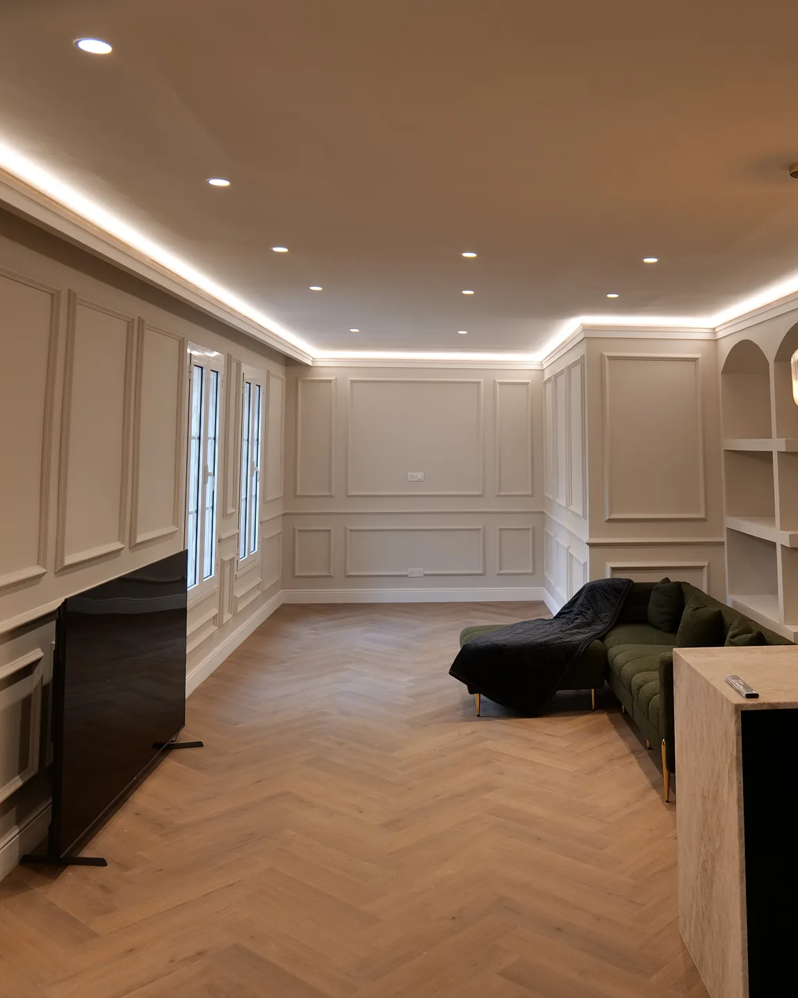 Le même séjour après la rénovation, avec moulures, parquet et éclairage indirect