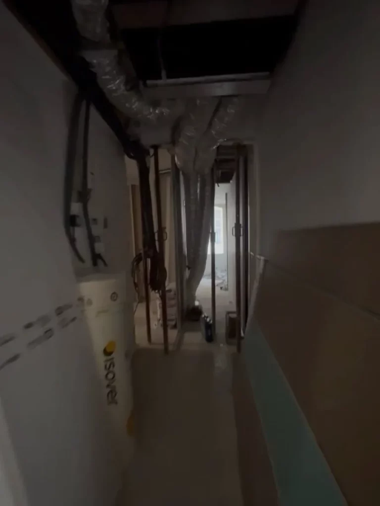 Couloir de l’appartement en chantier : gaines techniques passées en faux plafond