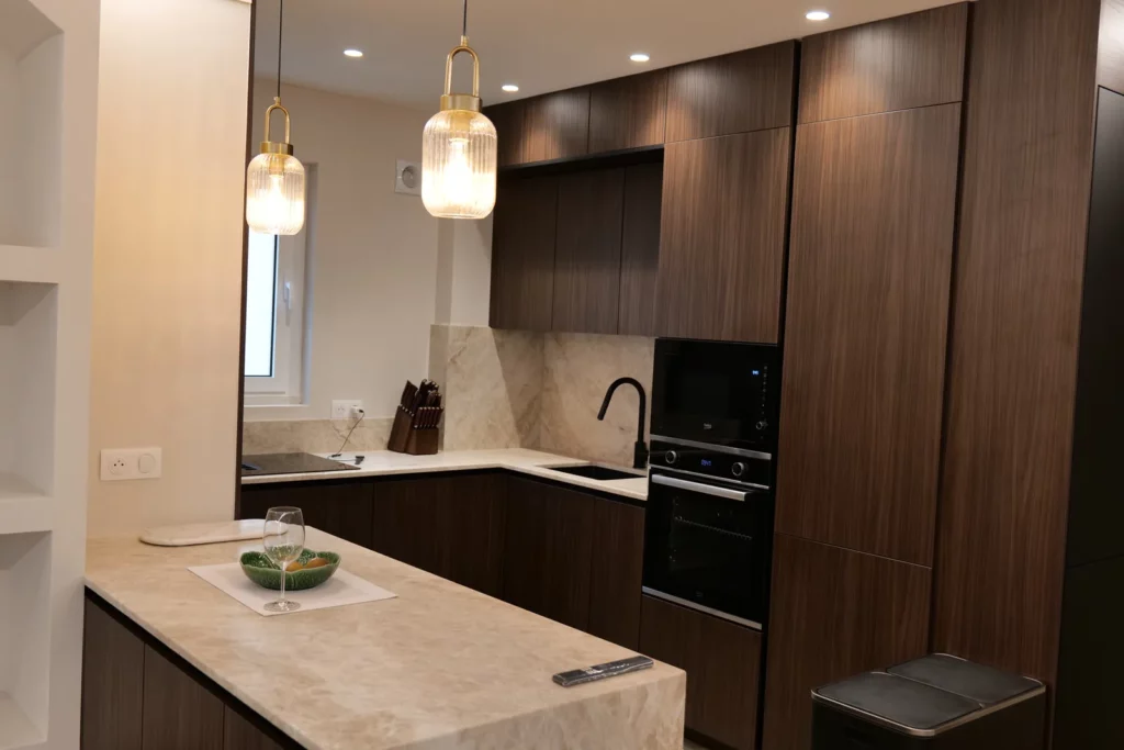 Cuisine rénovée avec îlot central et suspensions en verre strié, appartement à Avignon